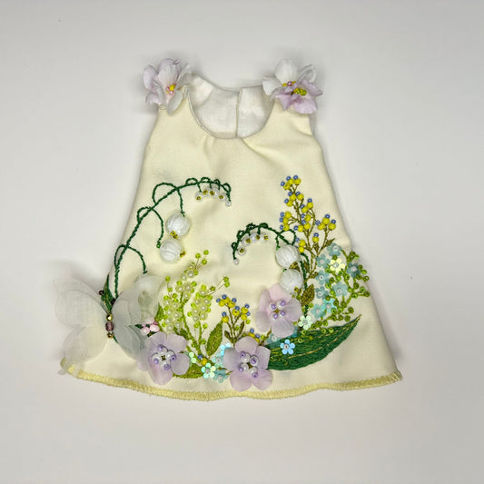 Doll dress with floral embroidery on a white background